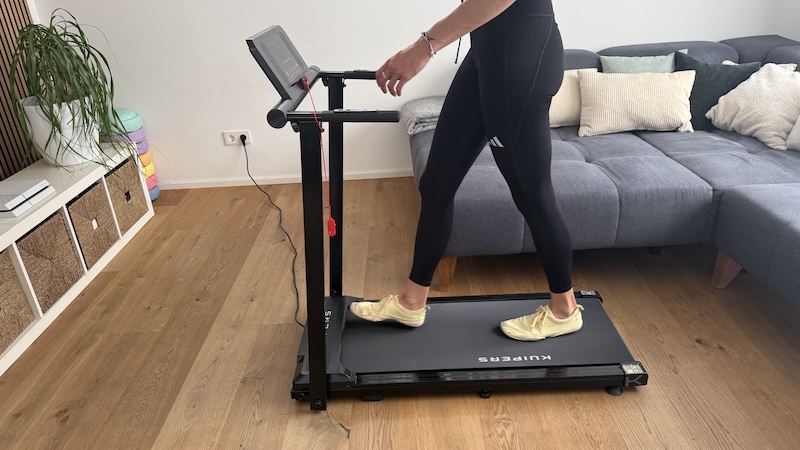 Kuipers R4 Laufband im Test: Ehrliches Fazit nach 4 Wochen 5 Kuipers R4 Walking Pad im Wohnzimmer vor dem Fernseher beim Gehen